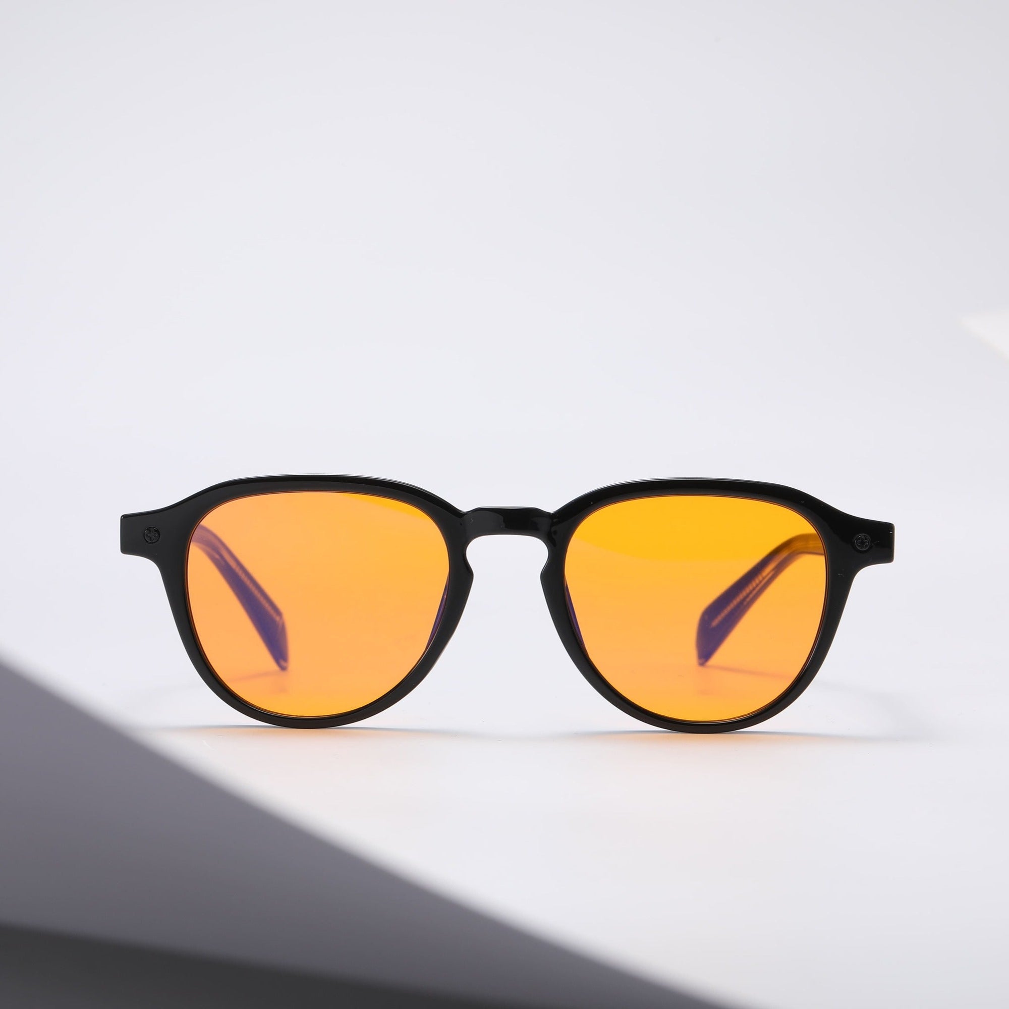 Black square-framed sunglasses with orange lenses on a white background.